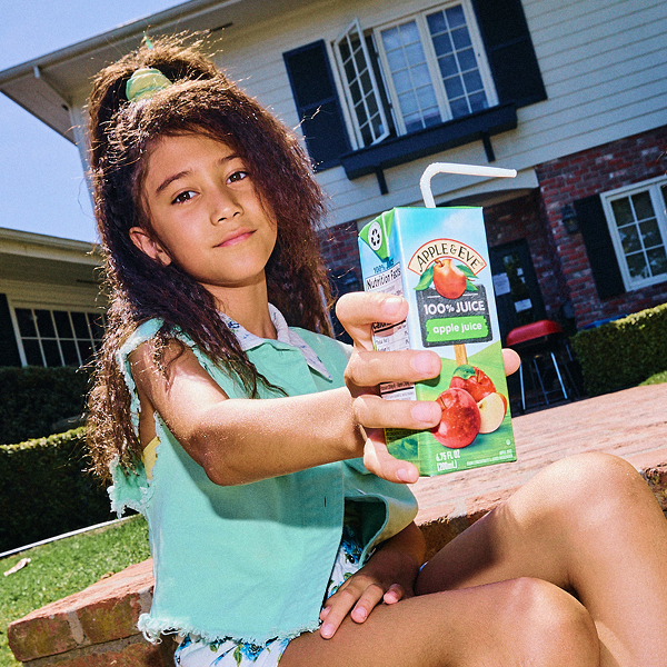 girl holding up a Apple Juice box