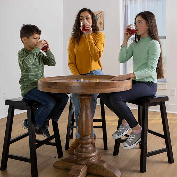 Mother and Kids sitting at a table drinking juice from glasses
